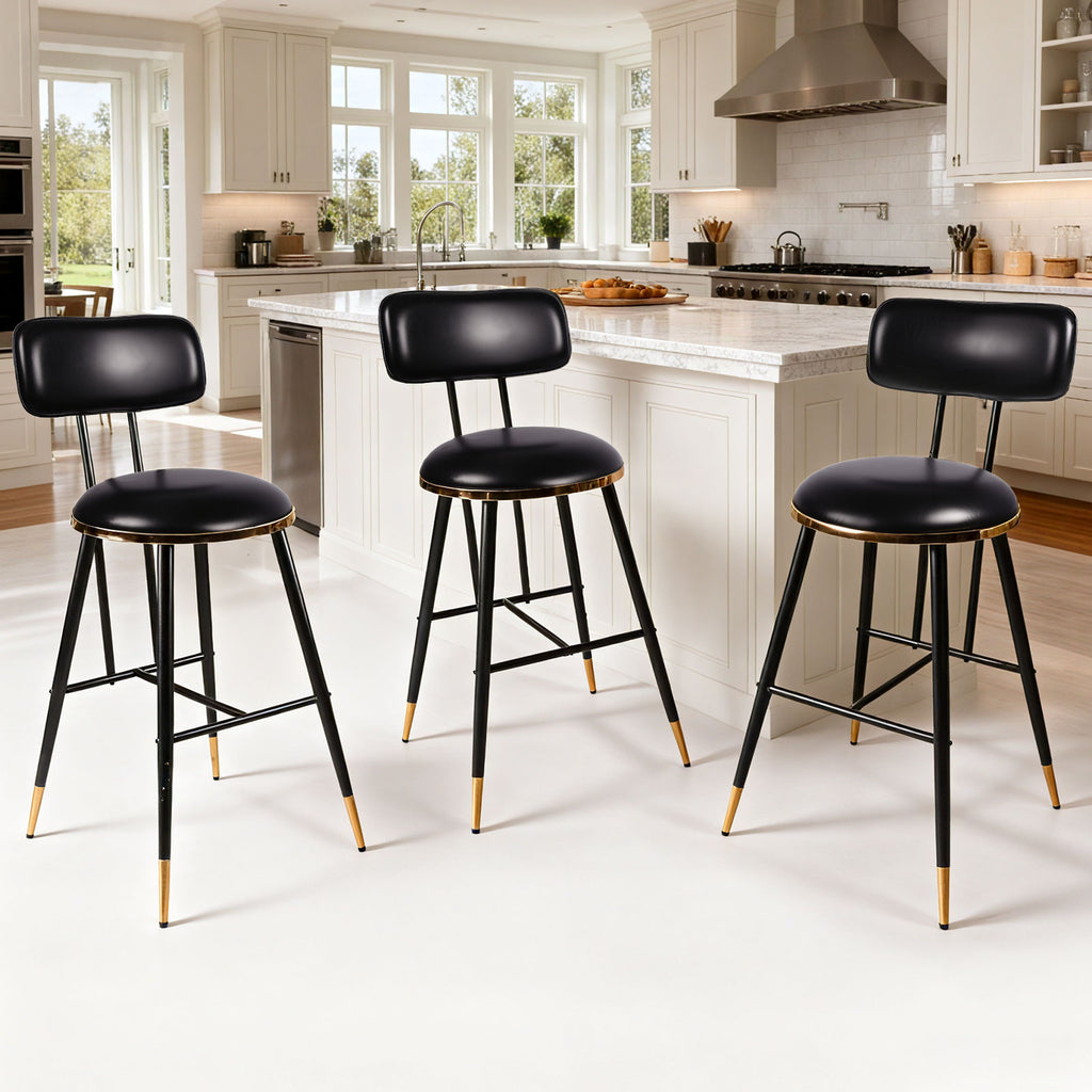 Three black bar stools with gold accents in a kitchen setting.