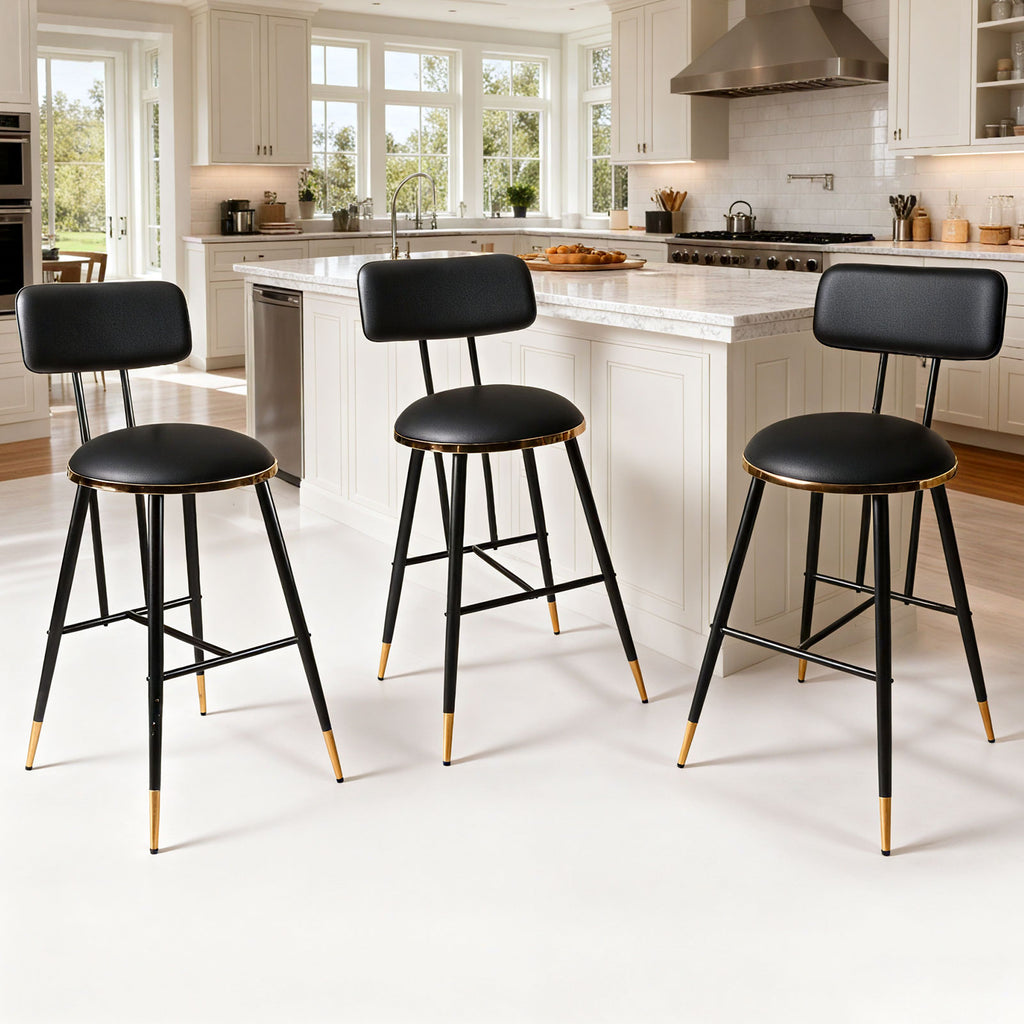 Three black bar stools with gold accents in a kitchen setting