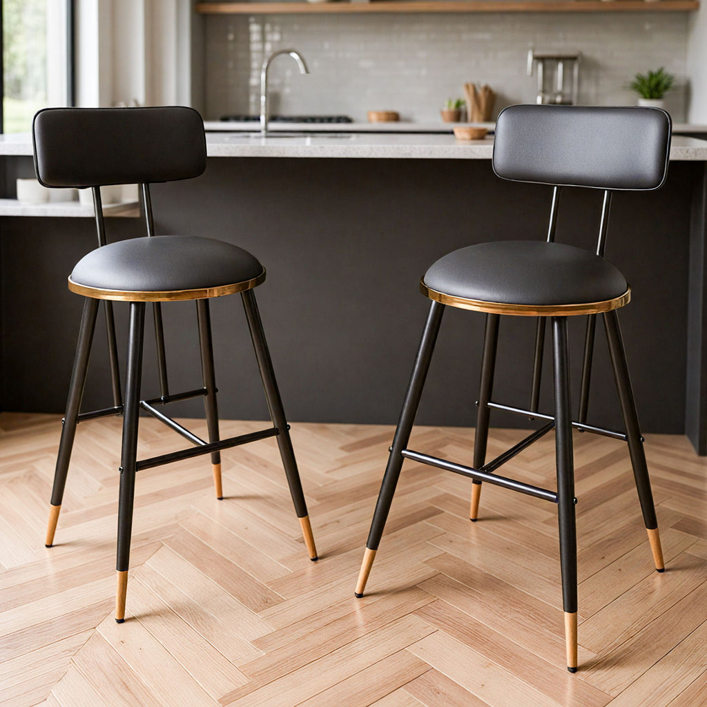 Two black bar stools with gold accents in a kitchen setting.