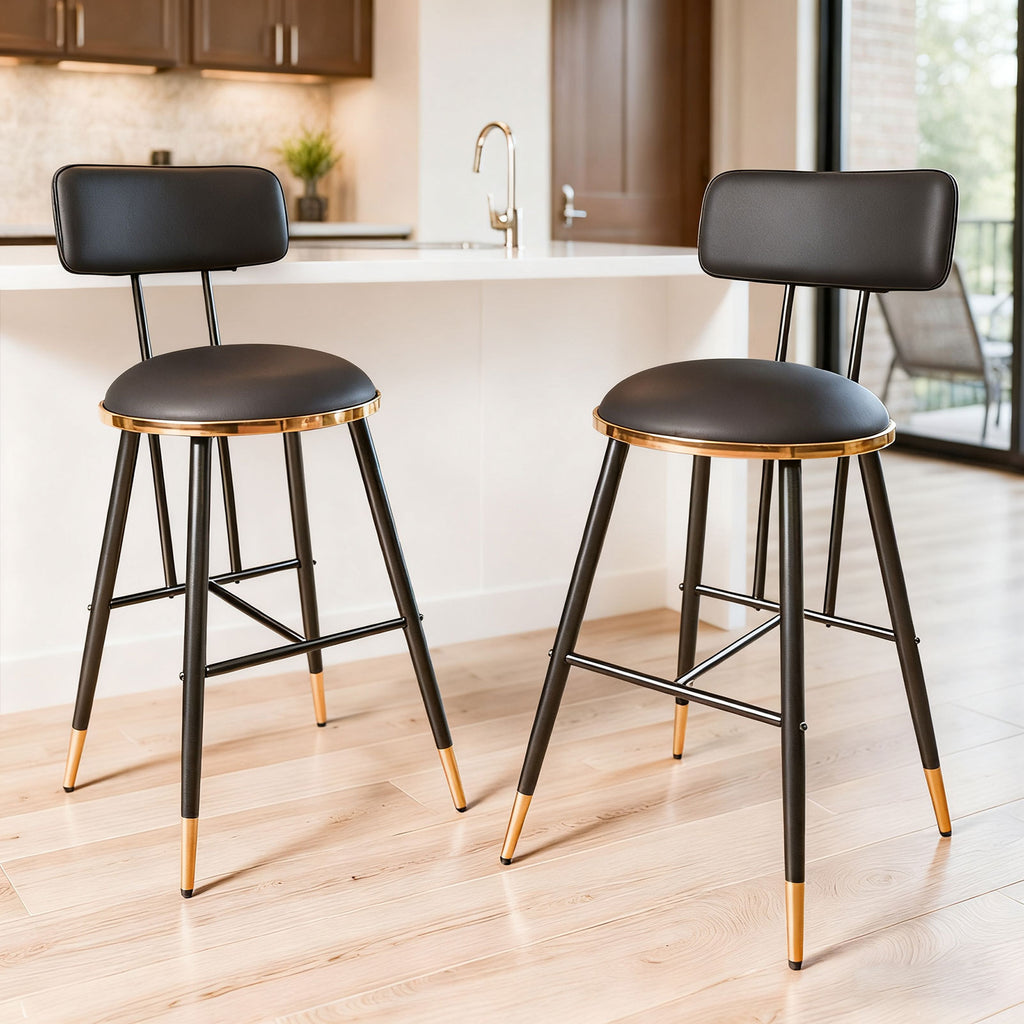 Two black bar stools with gold accents in a kitchen setting.