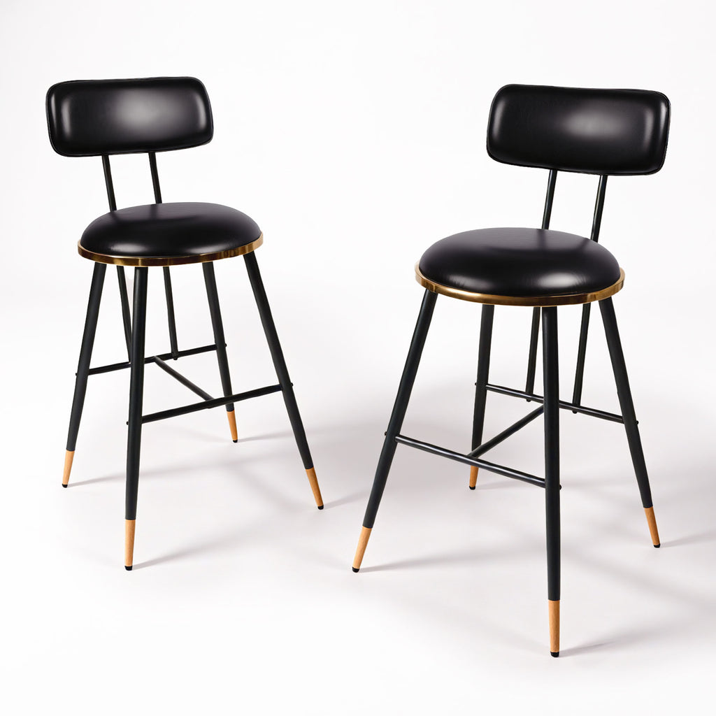Two black bar stools with golden seats on a white background
