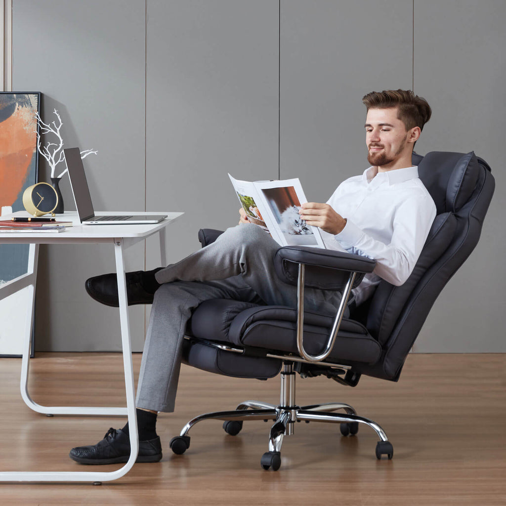 zzw_a_young_man_seat_office_chair_reclining_reading_in_an_office